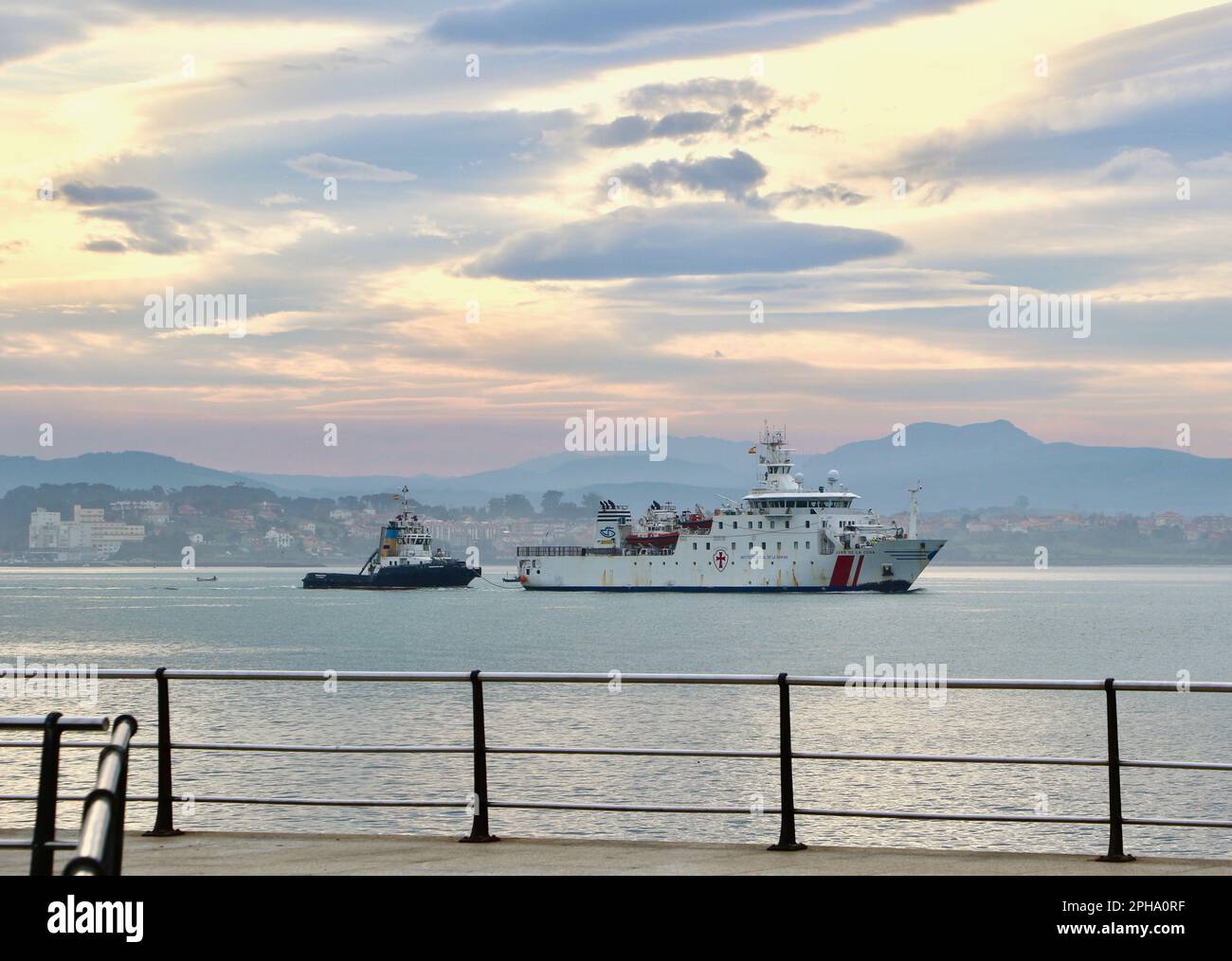 Juan de la Cosa Krankenhausschiff, das in den Hafen einläuft, mit Schlepper Trheintayuno hinter Santander Bay Cantabria Spanien Stockfoto