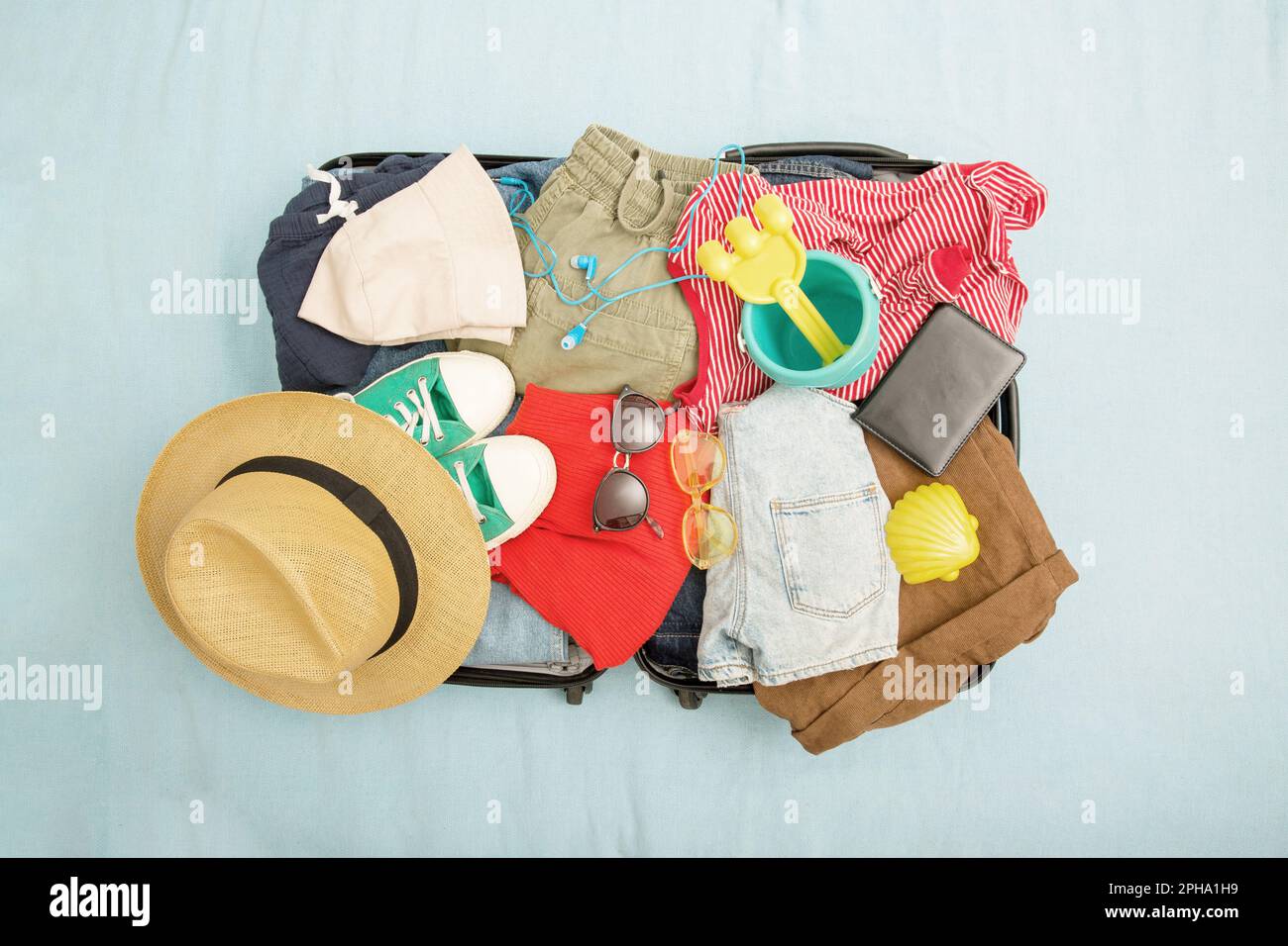 Offener Koffer und Gepäck mit verschiedenen eingepackten Kleidungsstücken. Reisekonzept. Draufsicht Stockfoto