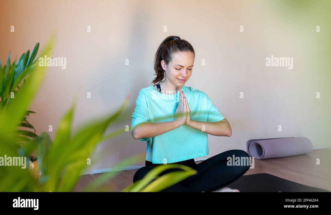 Junge brünette Frau meditiert in Lotusstellung. Stockfoto