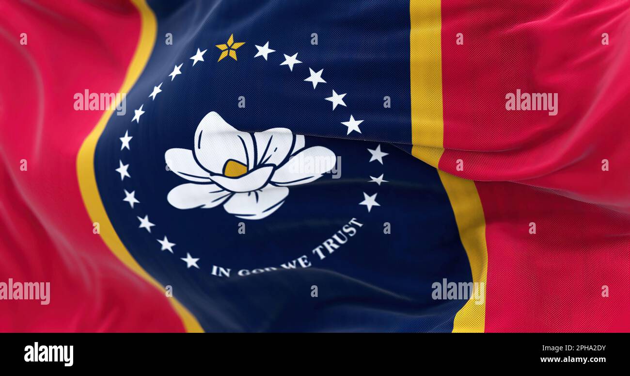 Mississippi Staatsflagge flattert. Blaues Mittelfeld mit roten Seitenbändern, goldenen Streifen. Magnolienblüte in der Mitte, umgeben von 20 weißen Sternen, La Stockfoto