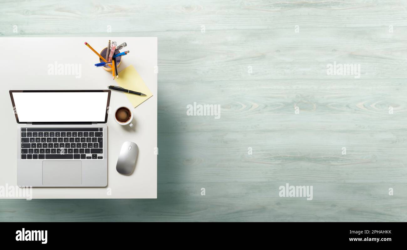 Laptop mit weißem Bildschirm auf dem Bürotisch. Draufsicht mit leerem Kopierbereich. Stockfoto