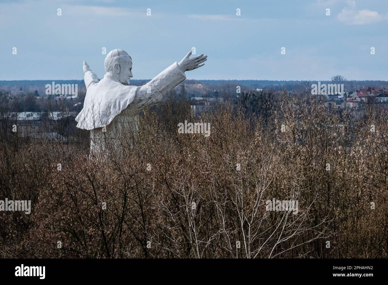 Das Denkmal für Johannes Paul II., das zwischen den Bäumen zu sehen ist. Das höchste Denkmal in Polen von Papst Johannes Paul dem Zweiten. Das Denkmal wurde 2013 erbaut und in Czestochowa platziert. Heute ist es vergessen. Keine Pilger kommen, um es zu sehen. Es bleibt allein unter den Bäumen. Stockfoto