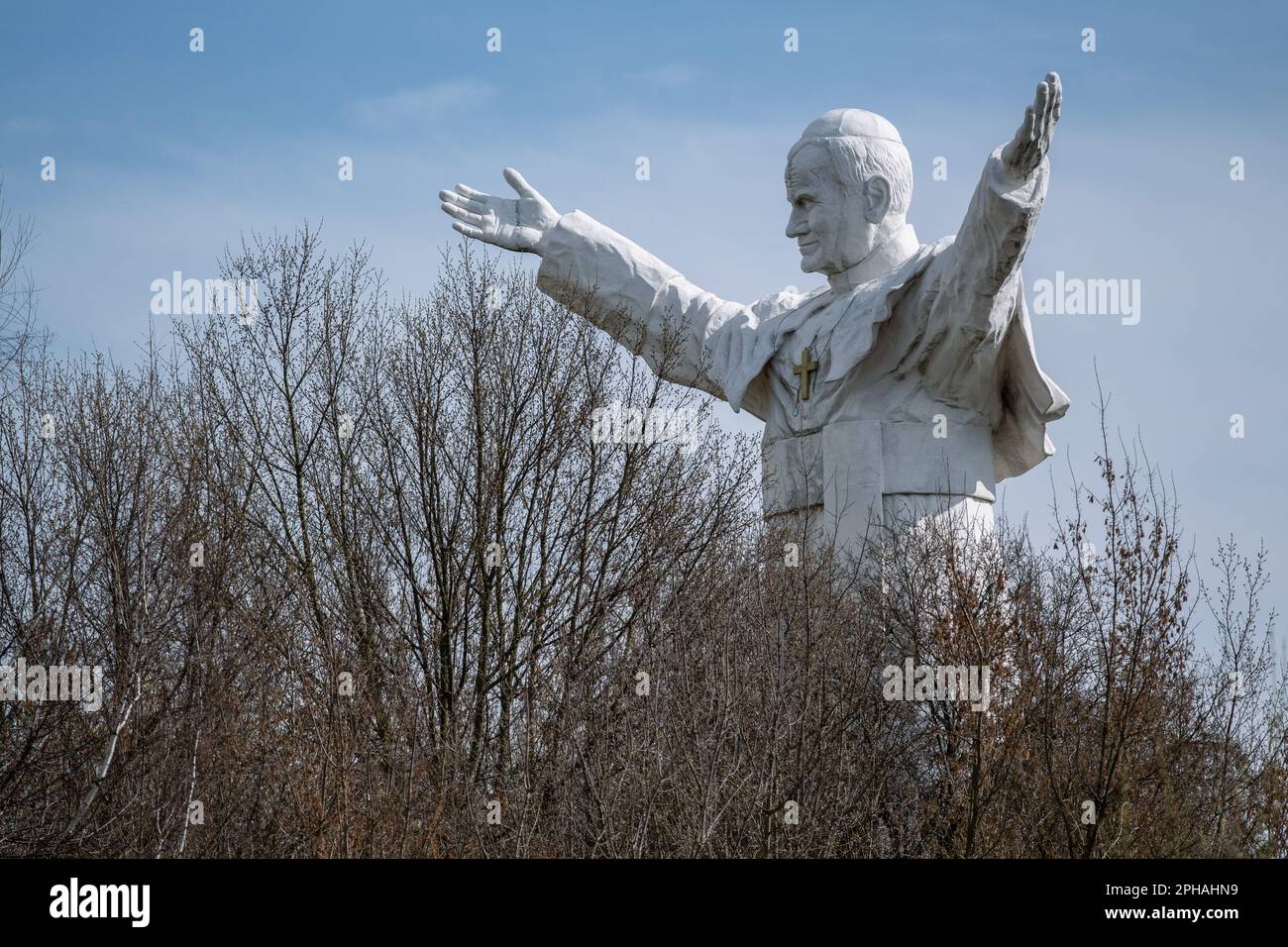 Das Denkmal für Johannes Paul II., das zwischen den Bäumen zu sehen ist. Das höchste Denkmal in Polen von Papst Johannes Paul dem Zweiten. Das Denkmal wurde 2013 erbaut und in Czestochowa platziert. Heute ist es vergessen. Keine Pilger kommen, um es zu sehen. Es bleibt allein unter den Bäumen. Stockfoto