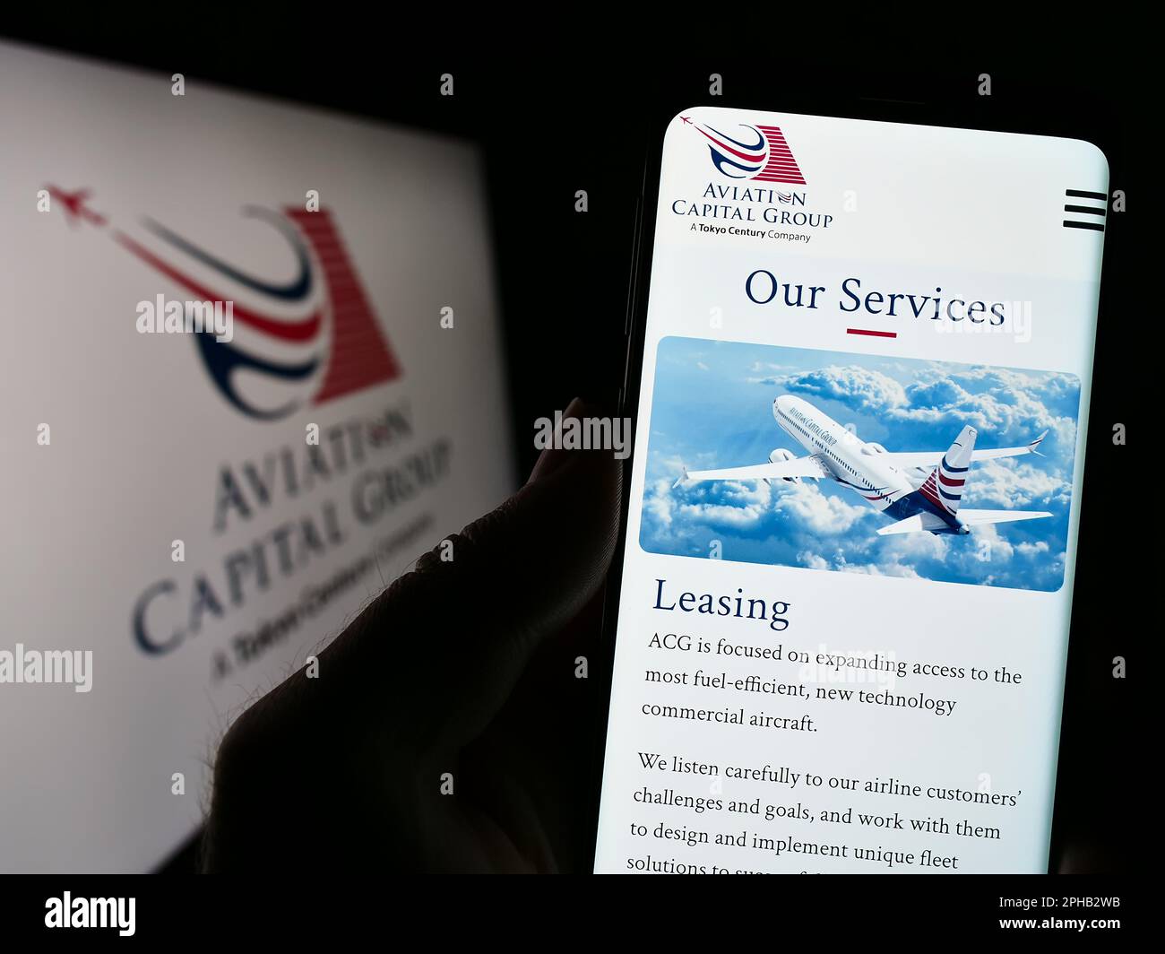 Person, die ein Mobiltelefon besitzt und die Webseite der US-Leasinggesellschaft Aviation Capital Group LLC auf dem Bildschirm mit Logo anzeigt. Konzentrieren Sie sich auf die Mitte des Telefondisplays. Stockfoto