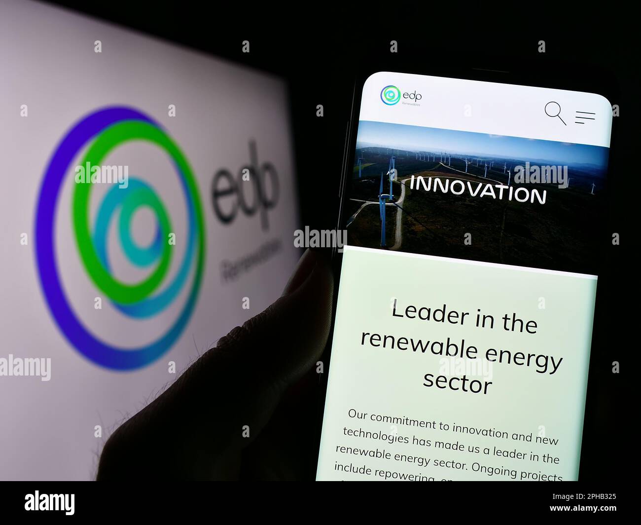 Person, die ein Smartphone mit der Webseite des spanischen Energieunternehmens EDP Renovaveis S.A. besitzt (EDPR) auf dem Bildschirm mit Logo. Konzentrieren Sie sich auf die Mitte des Telefondisplays. Stockfoto