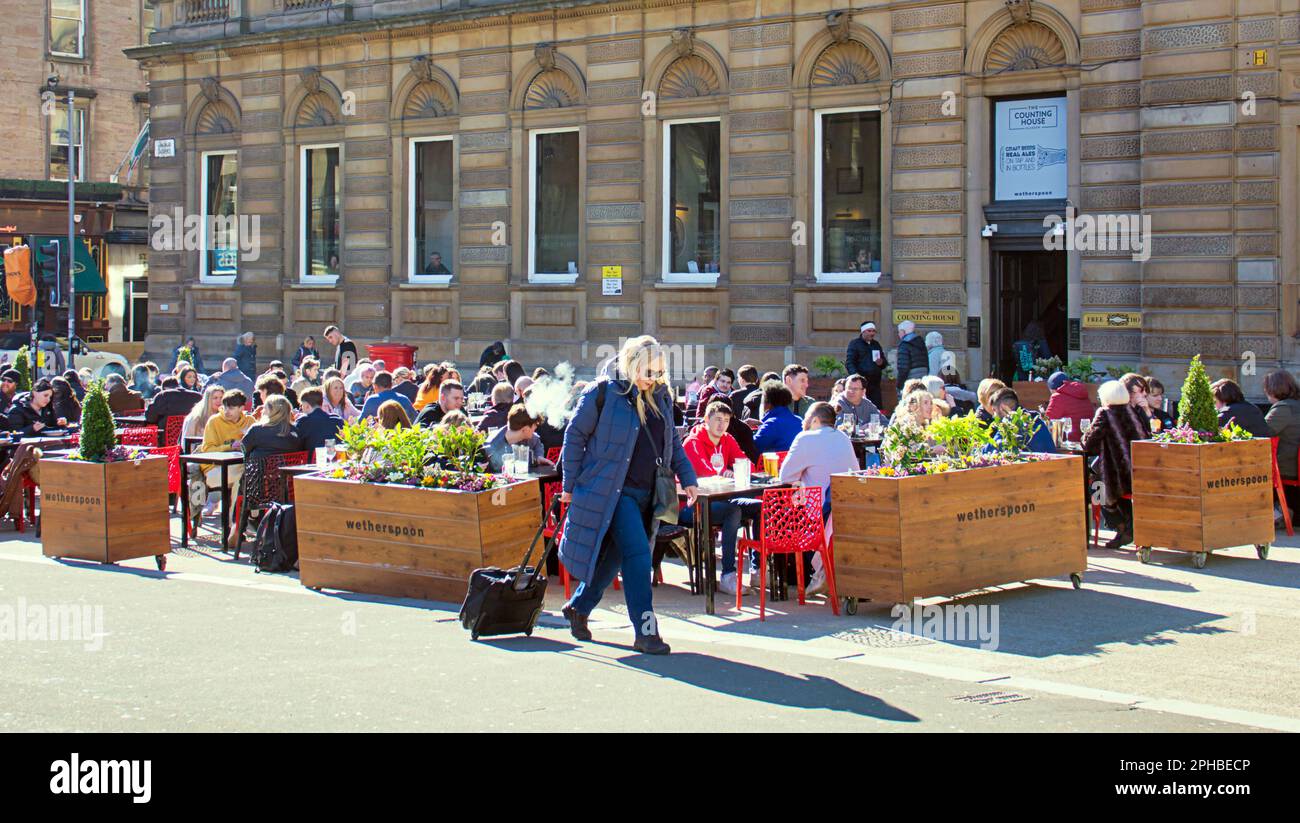 Glasgow, Schottland, Vereinigtes Königreich, 27. März 2023. UK Weather: Sonnig im Stadtzentrum am Nachmittag gingen die Einheimischen auf die Straße. Spaß auf dem george Square, wo Witherspoons zur Permament außerhalb der Tische für ihren Pub „The Counting House“ freigelassen wurden, um ihm ein mehr Kontinrntal Feeling zu geben. Credit Gerard Ferry/Alamy Live News Stockfoto