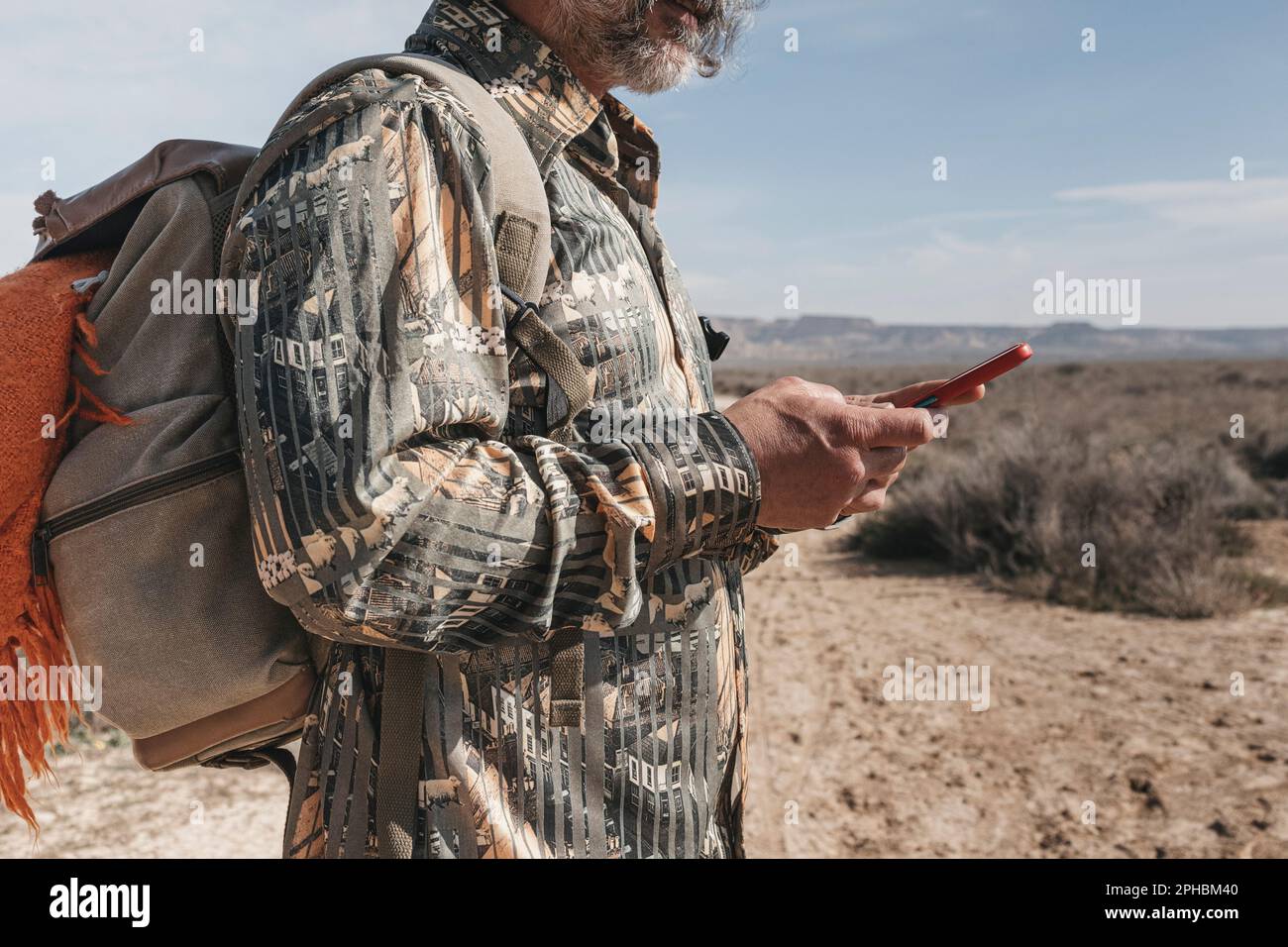 Ein Mann mittleren Alters, der ihr Smartphone auf einer Tageswanderung benutzt Stockfoto