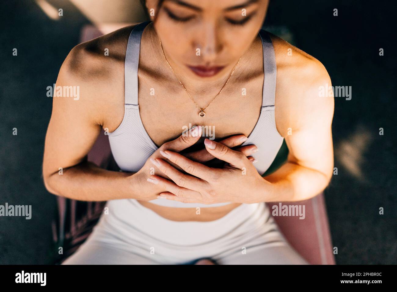 Aus dem Blickwinkel einer Frau, die mit den Händen auf der Brust trainiert Stockfoto