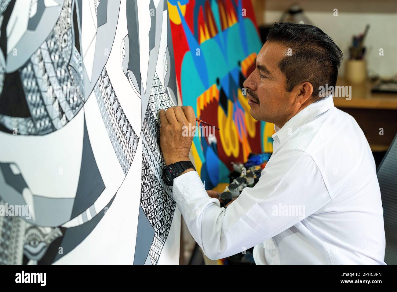 Der mexikanische Künstler Jacobo Angeles, der ein Gemälde im traditionellen Alebrije-Stil macht, San Martin Tilcajete, Oaxaca, Mexiko. Stockfoto