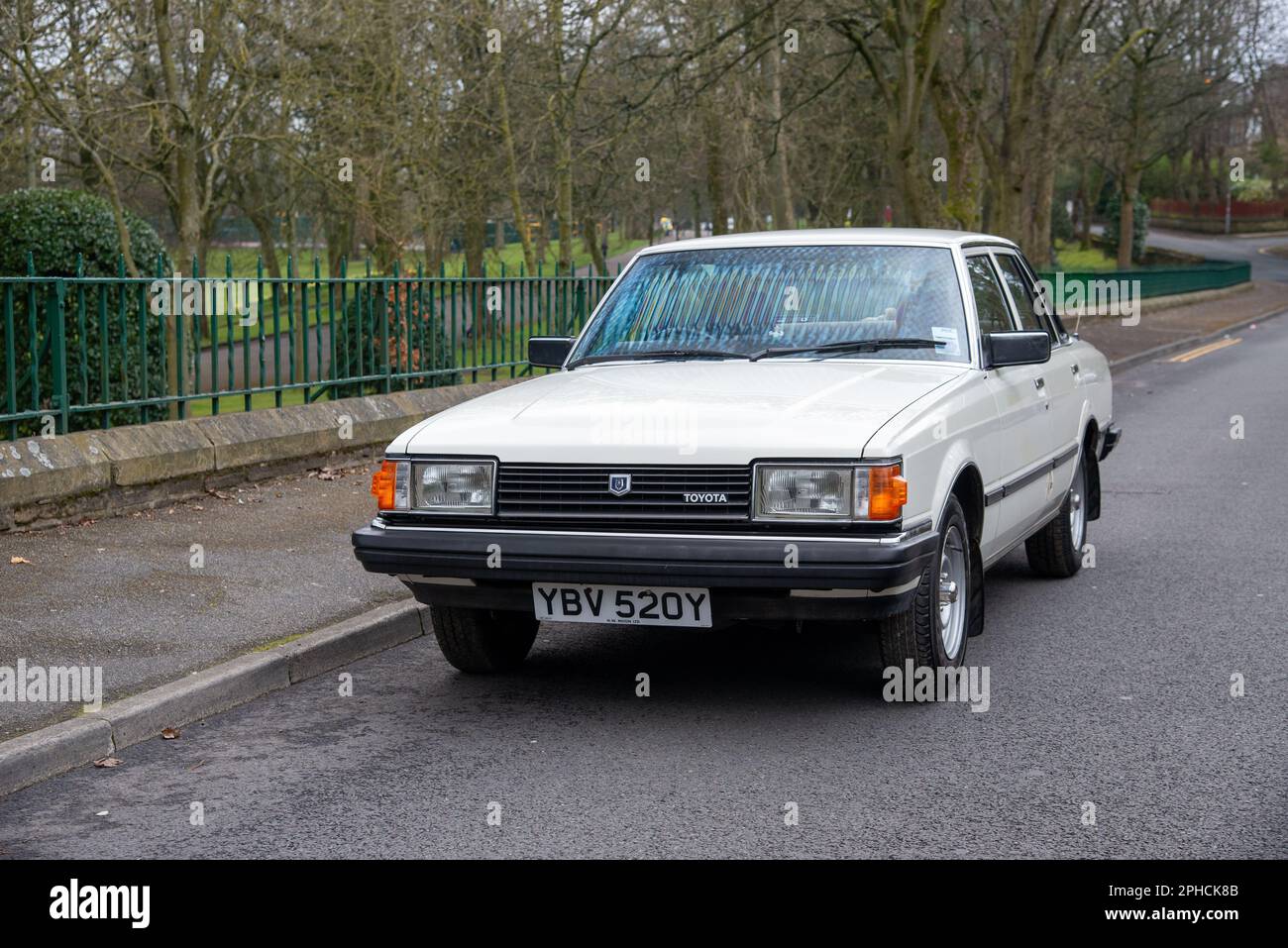 1982 Toyota Cressida DX parkte auf einer Vorstadtstraße mit Baumwipfeln und Parkflächen dahinter Stockfoto