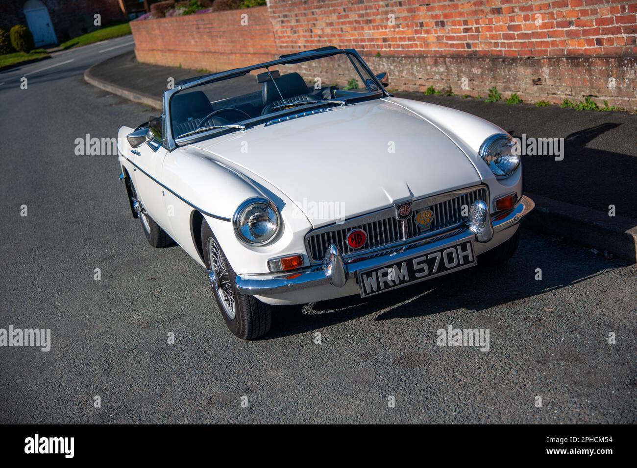 Chrom-Stoßfänger MGB Roadster britischer Klassiker parkt an einem sonnigen Frühlingstag auf einer Landstraße in einem Dorf Stockfoto