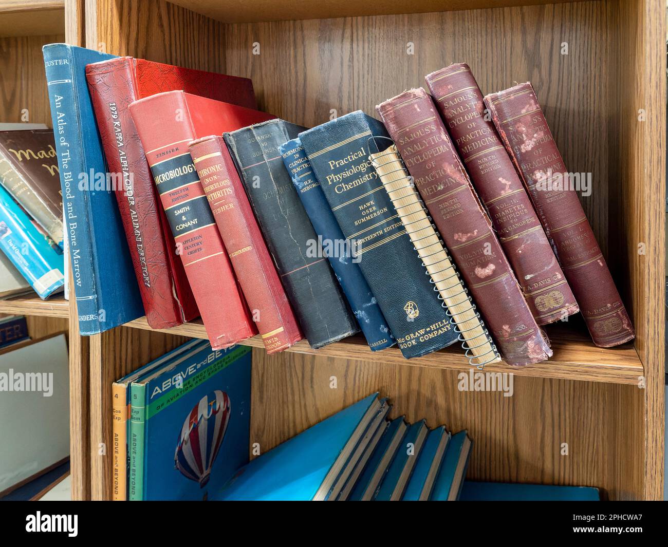 Alte medizinische Lehrbücher und wissenschaftliche Bücher auf einem Bücherregal in einem Antiquitätenladen oder Flohmarkt in Montgomery, Alabama, USA. Stockfoto