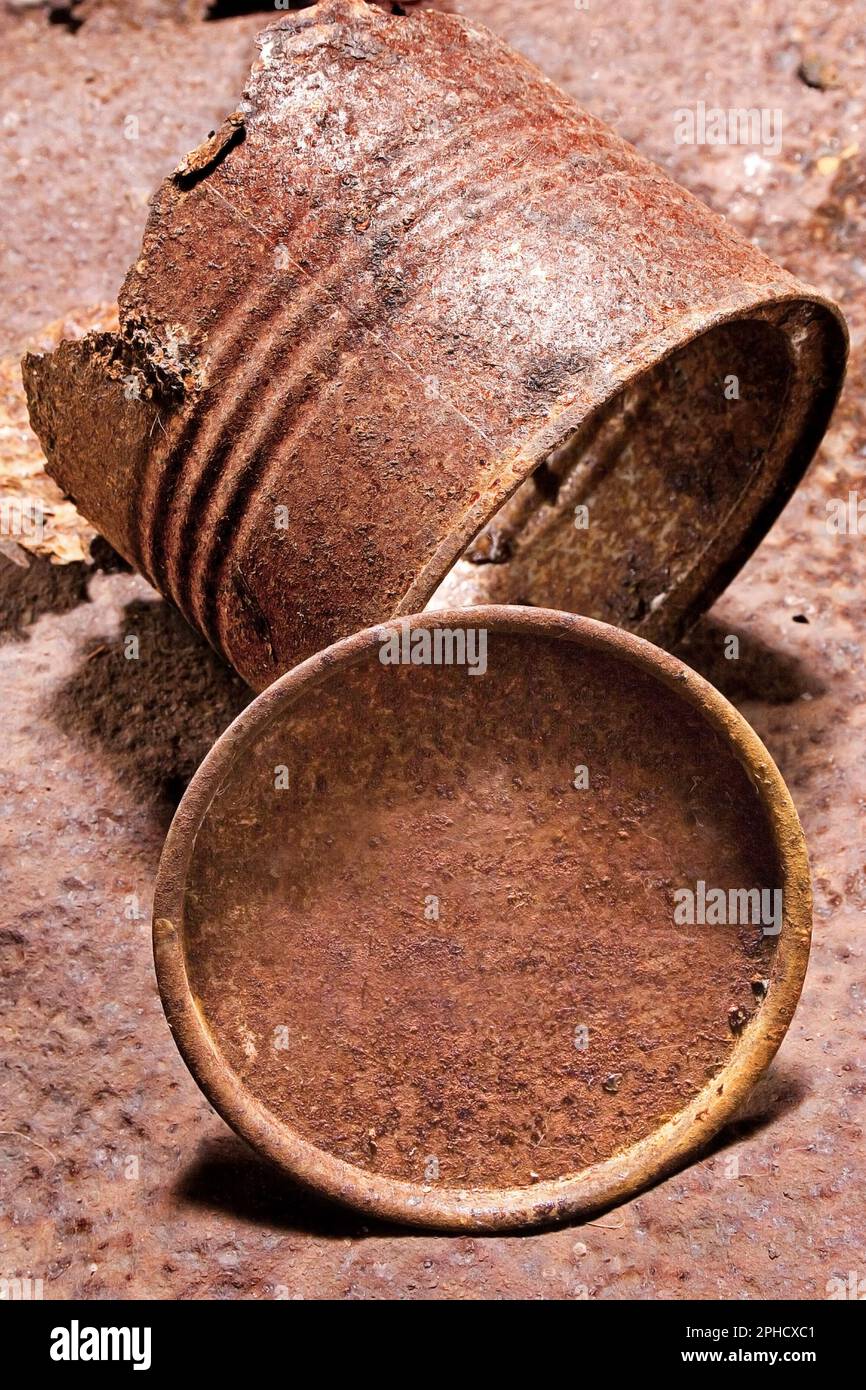 Kann durch Zeit und Rost zerstört werden. Eine Dose mit Milchpulver, die durch Rost zerstört wurde, wurde auf einem Trommeldeckel fotografiert, ebenfalls rostig. Stockfoto