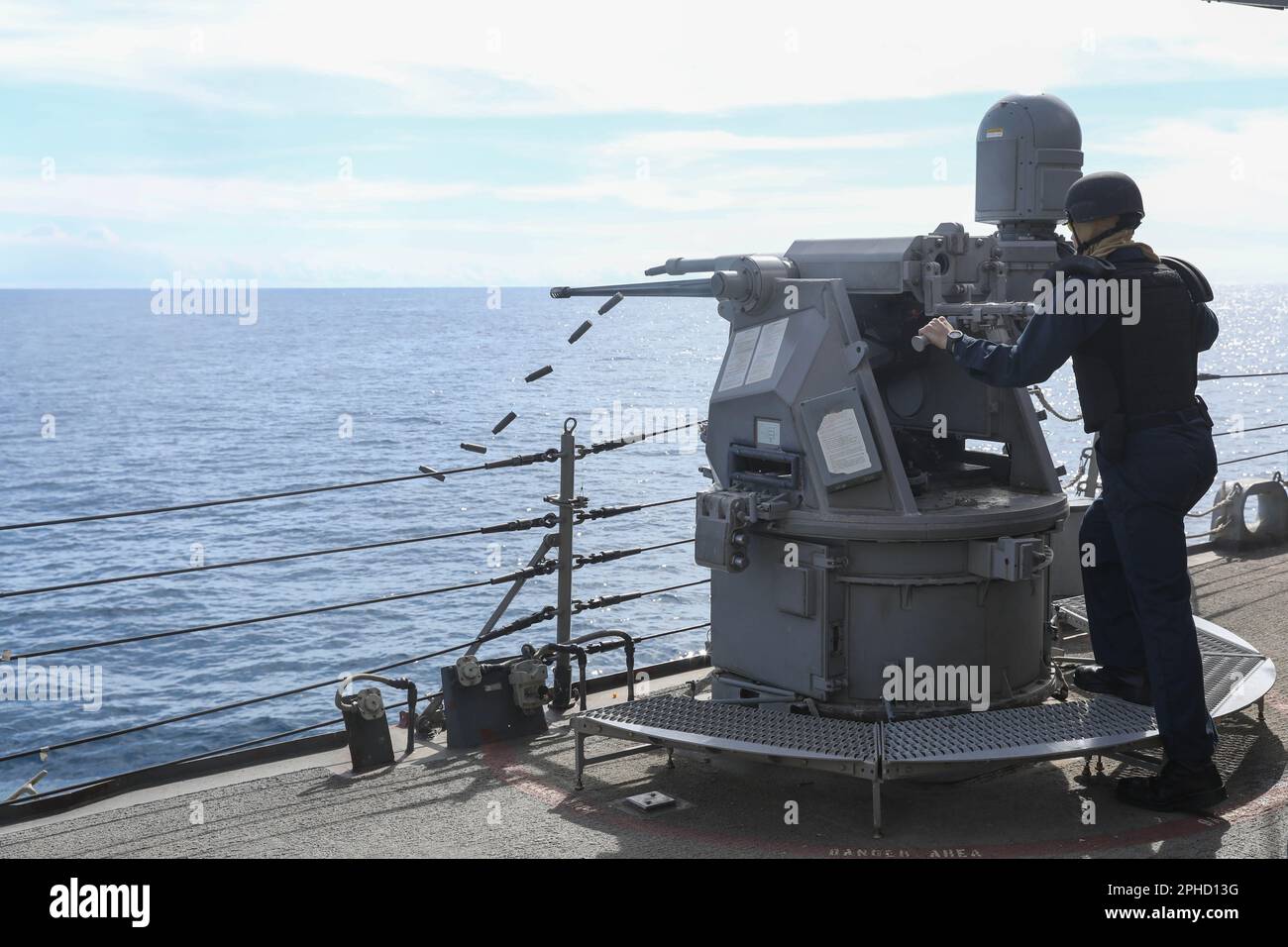 ATLANTIK (6. März 2023) Gunner's Mate 2. Klasse Elias Dvorak , dem Arleigh Burke-Klasse-Guided-Raketenzerstörer USS Ramage (DDG 61) zugeteilt, feuert die Mark 38 25mm Mod 2-Waffe während einer Live-Feuerübung ab, 6. März 2023. Stockfoto