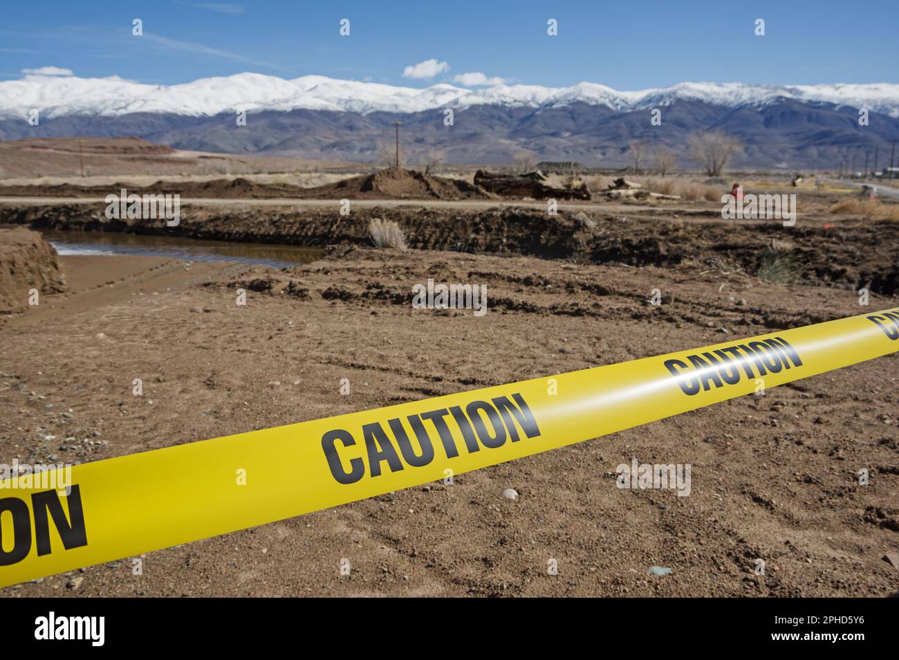 Gelbes Warnband vor einer Wasserspülung auf unbefestigten Straßen Stockfoto