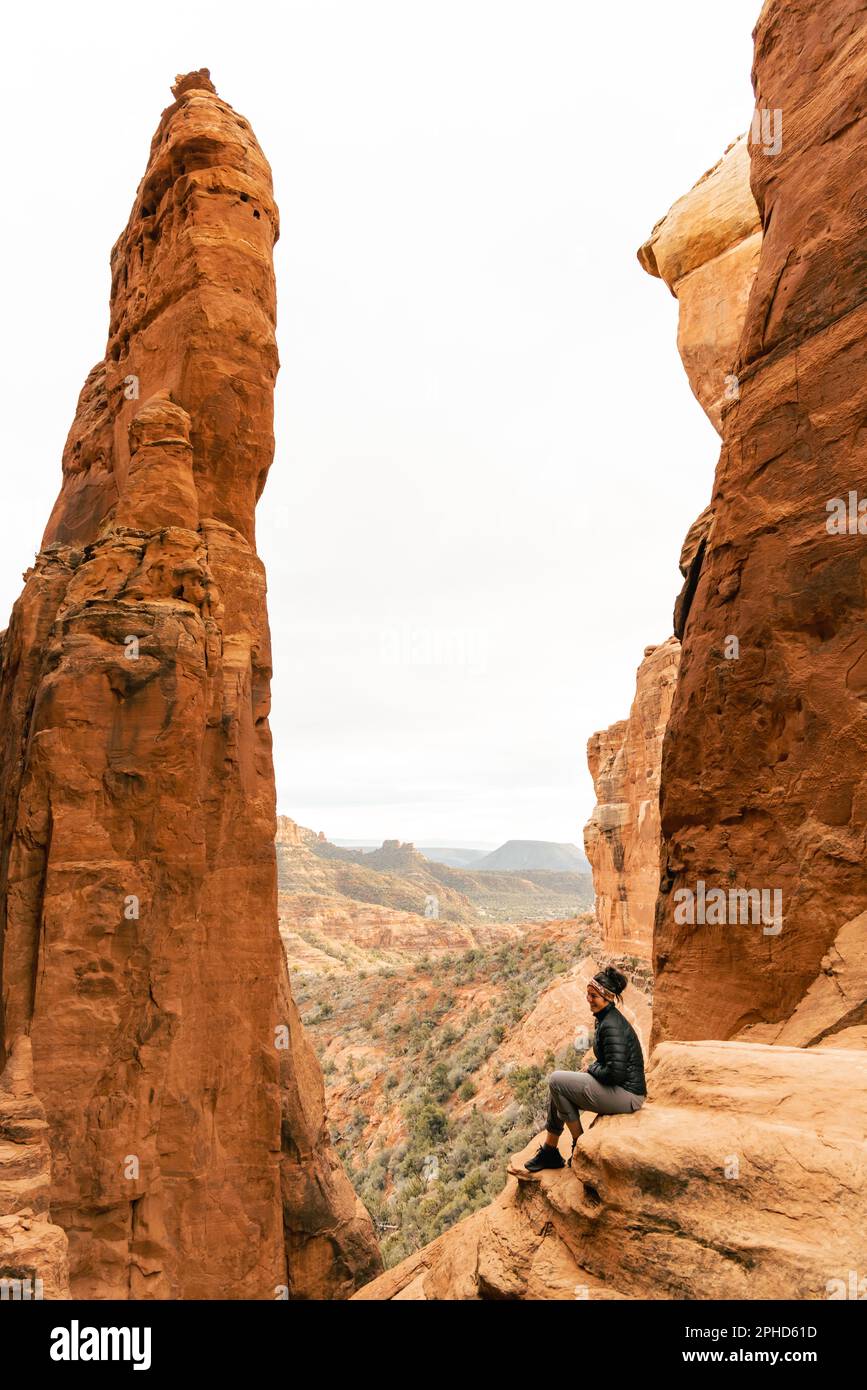 Die Frau genießt den Sonnenuntergang am Aussichtspunkt des Cathedral Rock Gipfels. Stockfoto