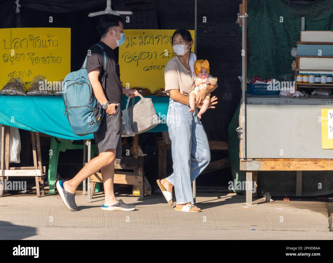 SAMUT PRAKAN, THAILAND, FEBRUAR 02 2023, Frauen gehen die Straße entlang mit einem Kind in den Händen Stockfoto