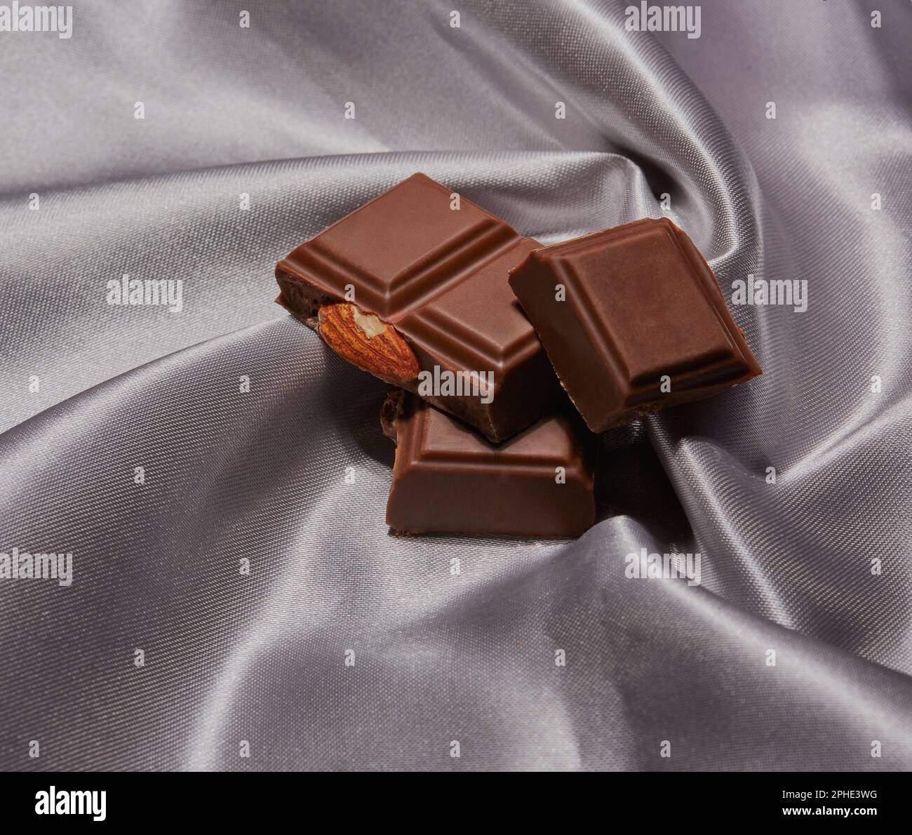 Obst- und Nussschokoladenriegel auf einem Stück Seide. Stockfoto