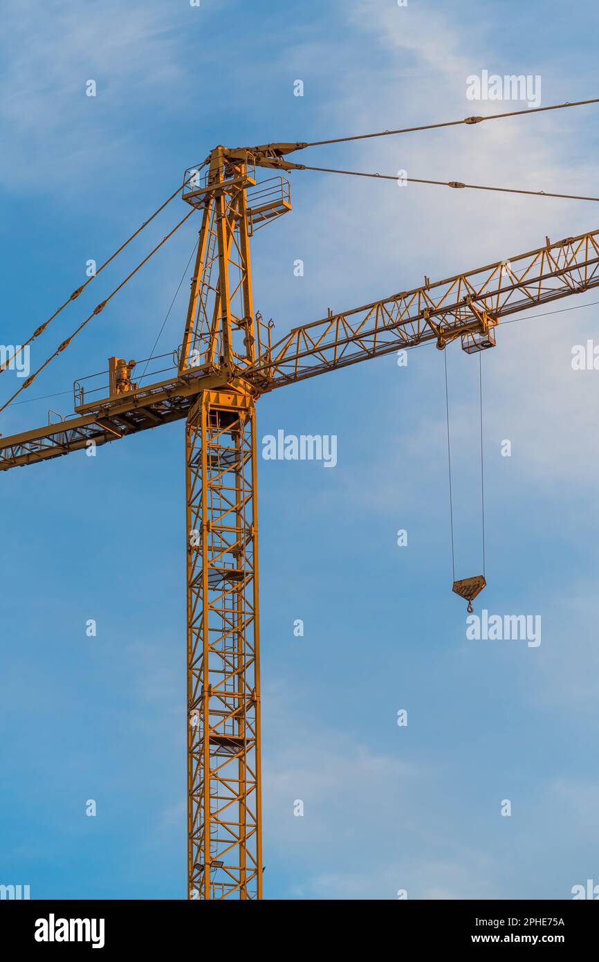 Gelbe industrielle Baukranmaschinen vor Ort vor blauem Himmel Stockfoto