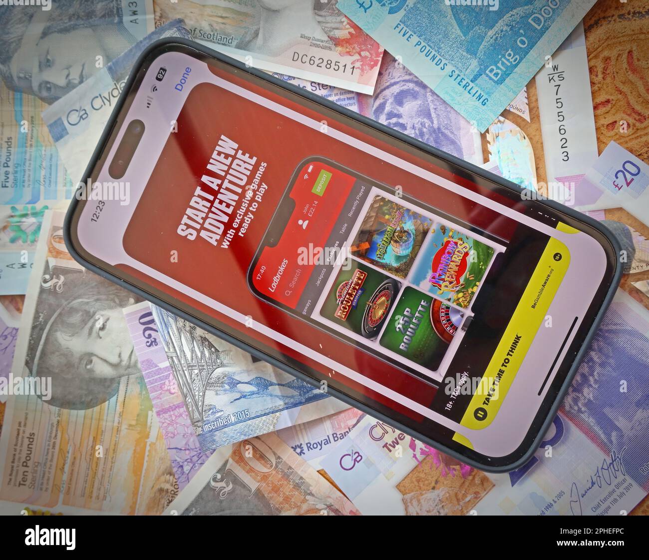 Ladbrokes Smartphone-App – Online- und Smartphone-Casino, Spielautomaten und Glücksspiel-App mit schottischen Sterling-Noten, Geld geht leicht verloren – BeGambleAware Stockfoto