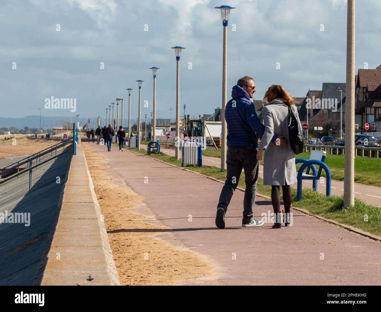 Ouistreham, Frankreich, 2023. Eine Frau und ein verliebter Mann wandern an einem wunderschönen sonnigen Frühlingstag am Meer in Ouistreham. Stockfoto