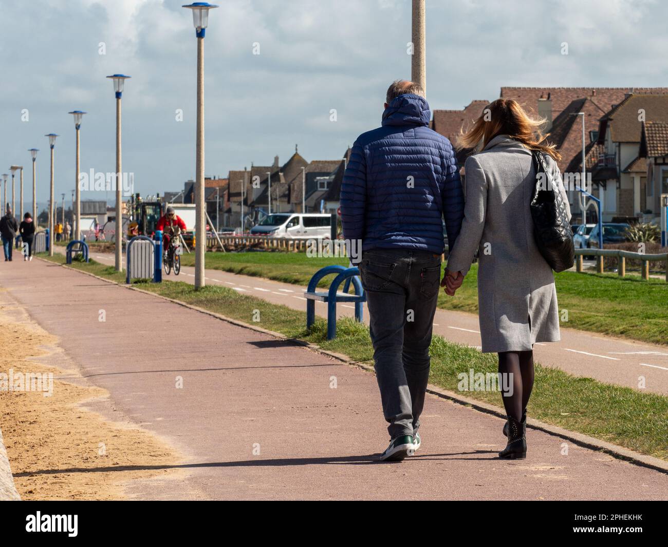 Ouistreham, Frankreich, 2023. Eine Frau und ein verliebter Mann wandern an einem wunderschönen sonnigen Frühlingstag am Meer in Ouistreham. Stockfoto