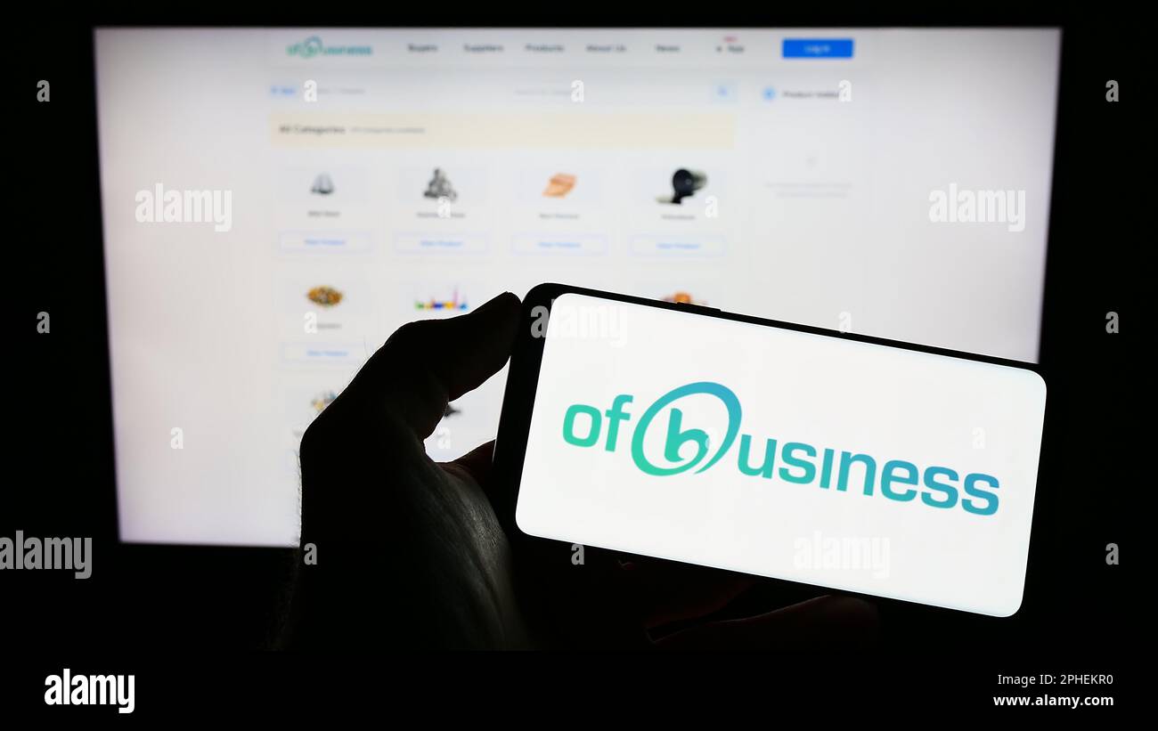 Person, die ein Mobiltelefon mit dem Logo der indischen Firma OFB Tech Pvt. Ltd. Besitzt (Des Geschäfts) auf dem Bildschirm vor der Webseite. Konzentrieren Sie sich auf das Display des Telefons. Stockfoto