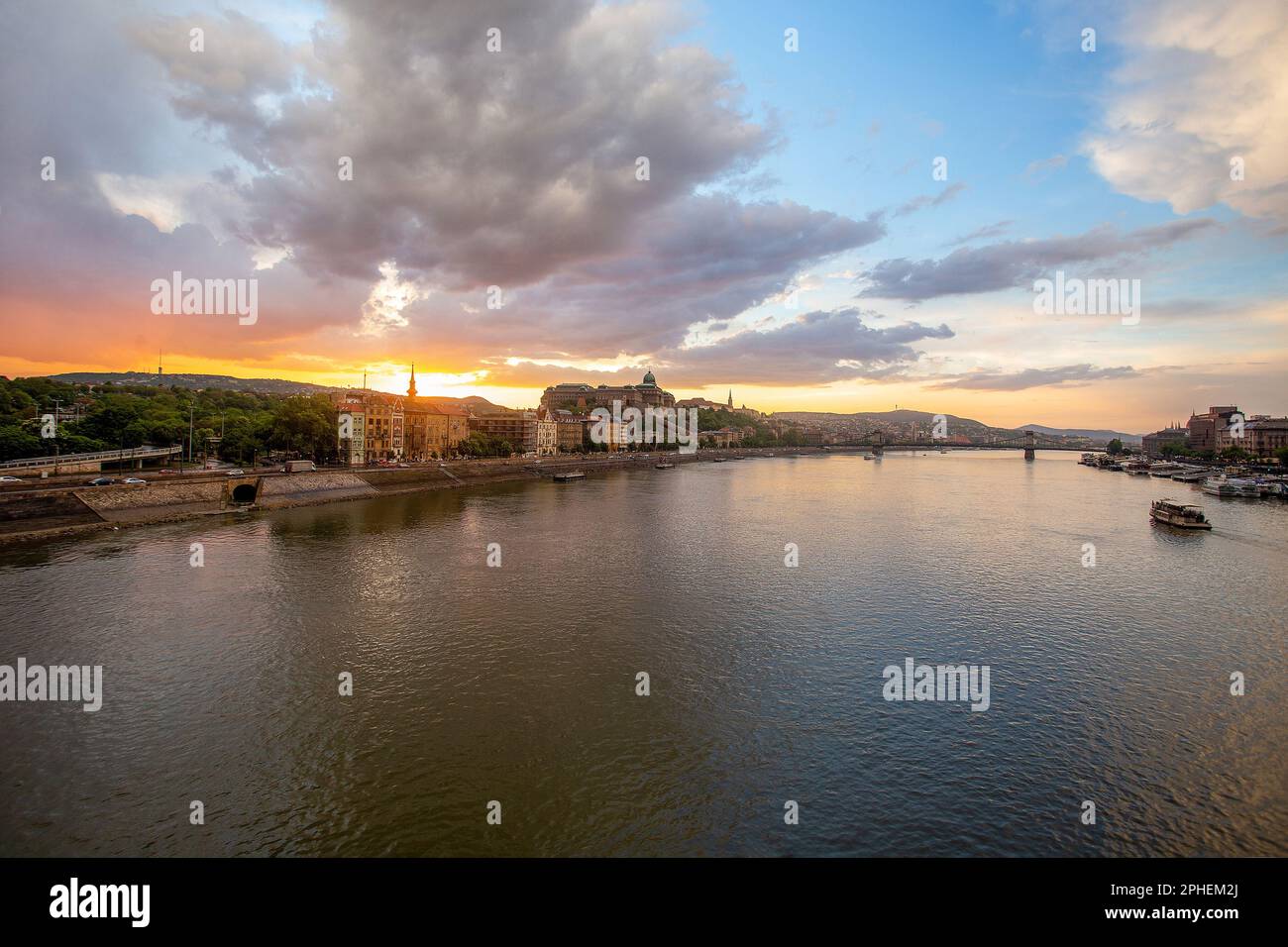 Fantastisches Stadtbild von Budapest mit Königspalast (Budavari Palota) und orangefarbenem Sonnenuntergang über der Stadt und der Donau. Der Frühling kommt! Stockfoto