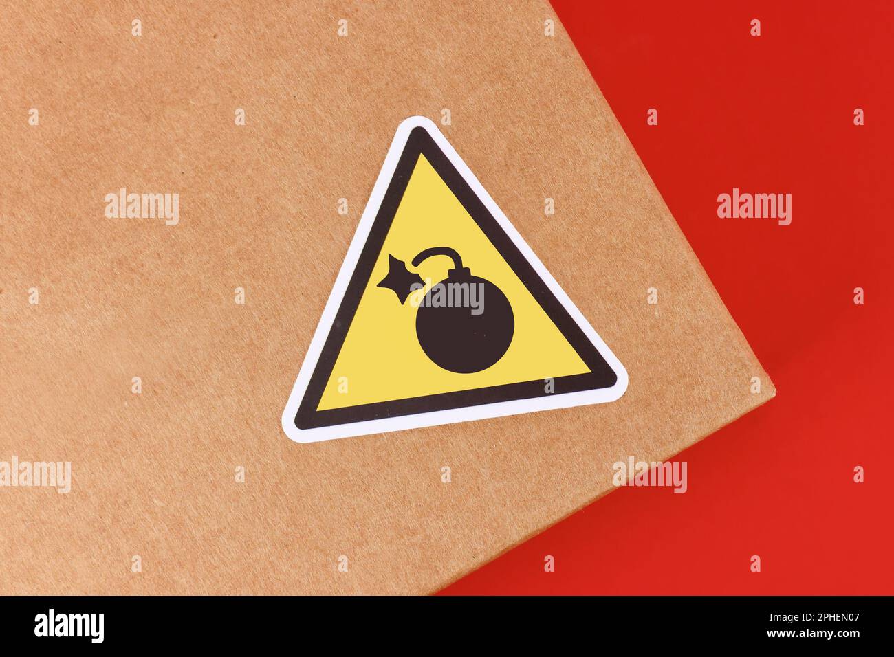 Dreieckiges Warnschild mit Bombensymbol auf dem Paket Stockfoto