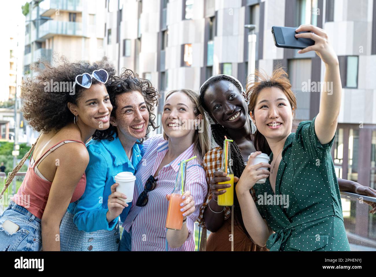 Eine Gruppe von Freundinnen macht Selfie-Fotos, lächelt vor der Kamera, lächelt junge Mädchen, die draußen stehen und Spaß haben, Porträtfotografie Stockfoto