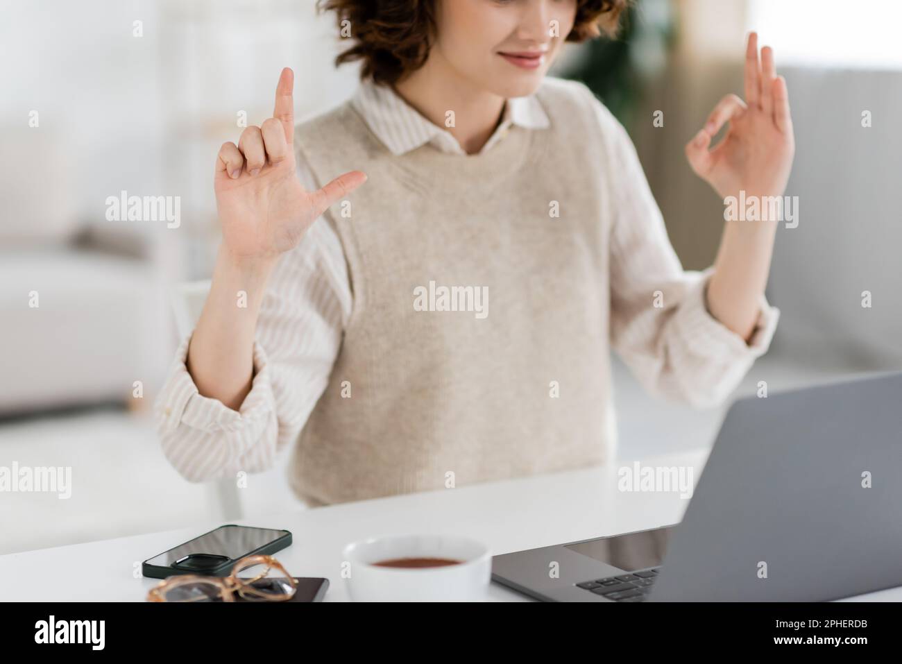 Zugeschnittene Ansicht des Zeichenstimmenlehrers mit alphabetischen Zeichen während des Online-Unterrichts auf einem Laptop zu Hause, Stockbild Stockfoto