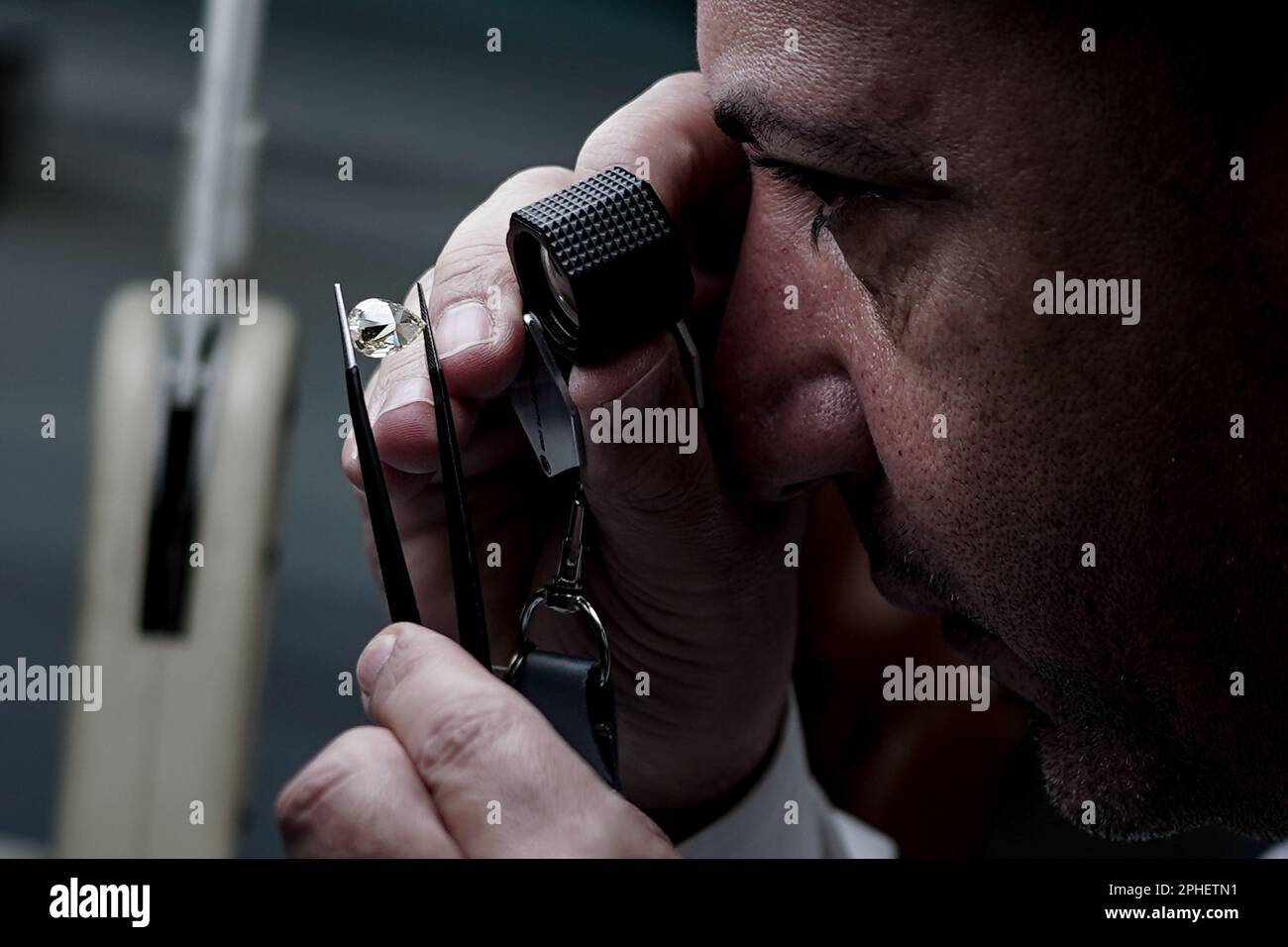 Ramat Gan, Israel. 28. März 2023. Ein Mann studiert einen Diamanten auf einer internationalen Diamantenausstellung im Rahmen der Internationalen Diamantenwoche Israel 2023, die von der Israel Diamond Exchange veranstaltet wird. Kredit: Nir Alon/Alamy Live News Stockfoto