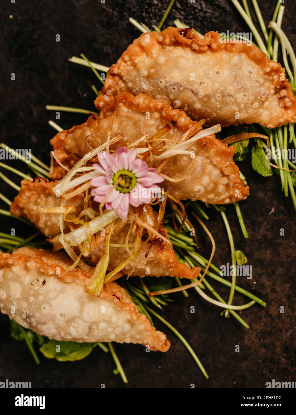 Ein Nahbild eines Tellers frittiertes Essen, garniert mit einer Blume Stockfoto