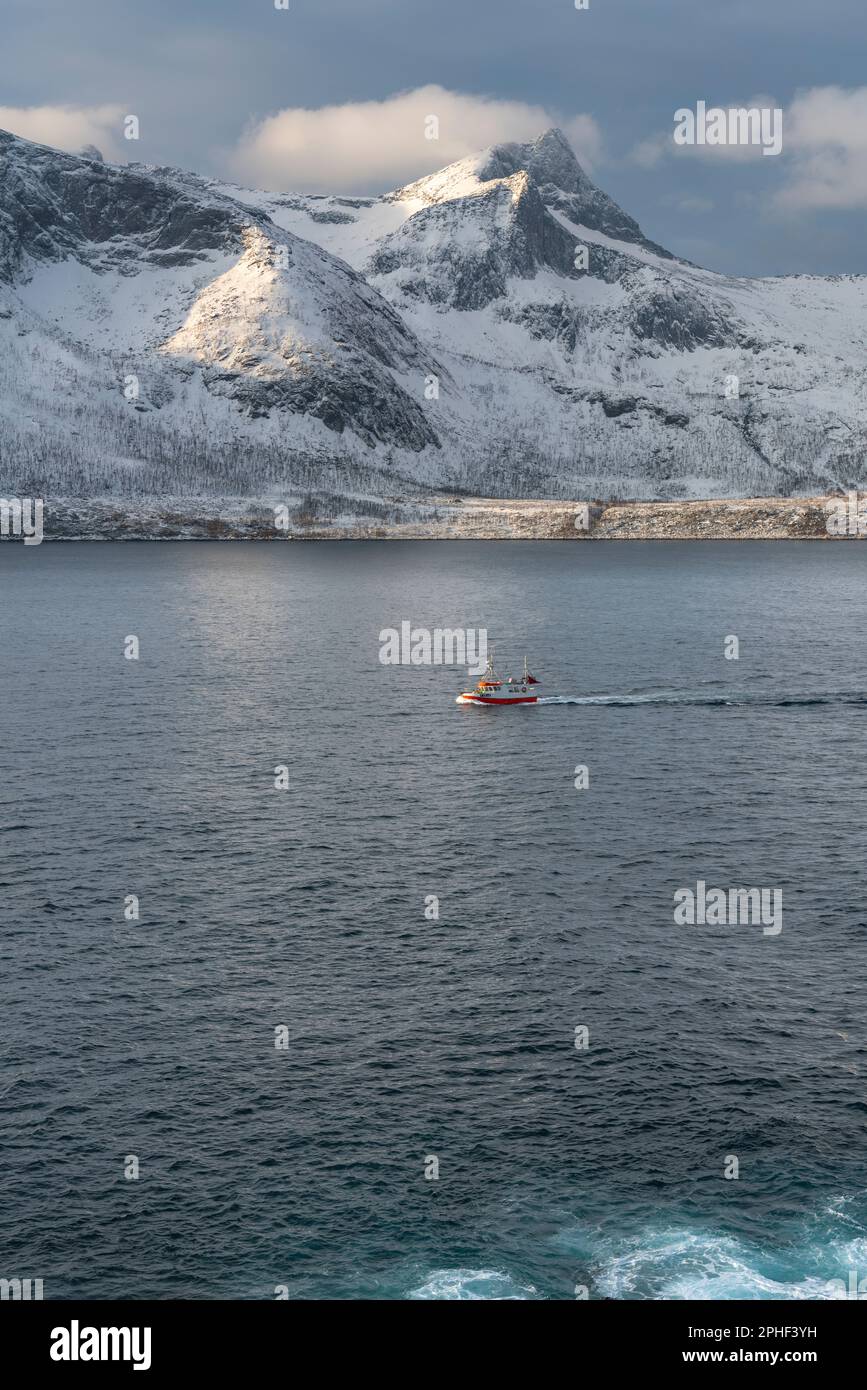 Fischer am Morgen, Schiff im Øyfjorden, mit den schneebedeckten Bergen von Senja, genannt Segla, Kongan und Skultran im Hintergrund. Norwegen Stockfoto