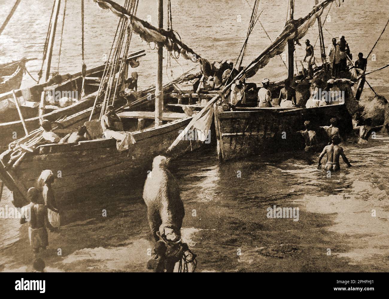 WWI - Indische Boote, die für Kamele verwendet werden, um in der Ostafrika-Kampagne in der Wüste eingesetzt zu werden. --- प्रथम विश्व युद्ध - पूर्वी अफ्रीका अभियान में रेगिस्तानी संचालन के लिए इस्तेमाल किए जाने वाले ऊंटों को ले जाने के लिए भारतीय नौकाओं का उपयोग किया जा रहा है। -- پہلی جنگ عظیم - مشرقی افریقہ کی مہم میں صحرائی کارروائیوں کے لئے اونٹ لے جانے کے لئے ہندوستانی کشتیوں کا استعمال کیا جا رہا ہے۔ --- Stockfoto