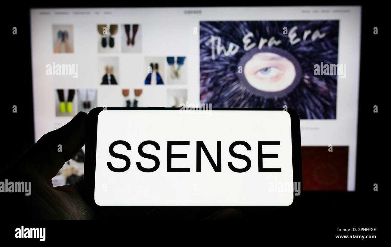 Person, die ein Smartphone mit dem Logo des kanadischen E-Commerce-Unternehmens SSENSE auf dem Bildschirm vor der Website hält. Konzentrieren Sie sich auf das Display des Telefons. Stockfoto