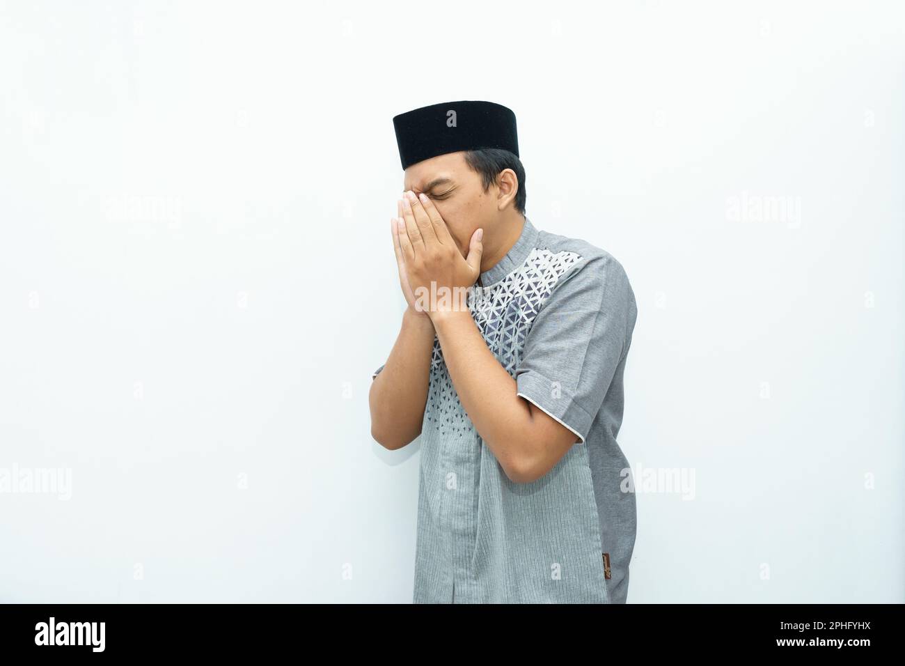 Porträt eines indonesisch-asiatischen Moslems mit niesender Geste Stockfoto