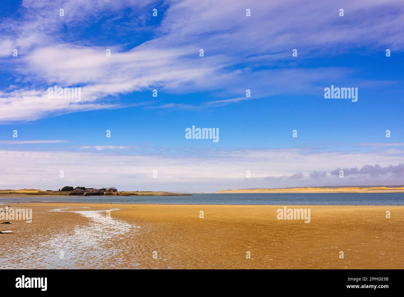 Blick über den Sand nach Fort Belan mit Newborough Beach auf Anglesey über Menai Strait. Dinas Dinlle, Caernarfon, Gwynedd, Nordwales, Vereinigtes Königreich, Großbritannien Stockfoto