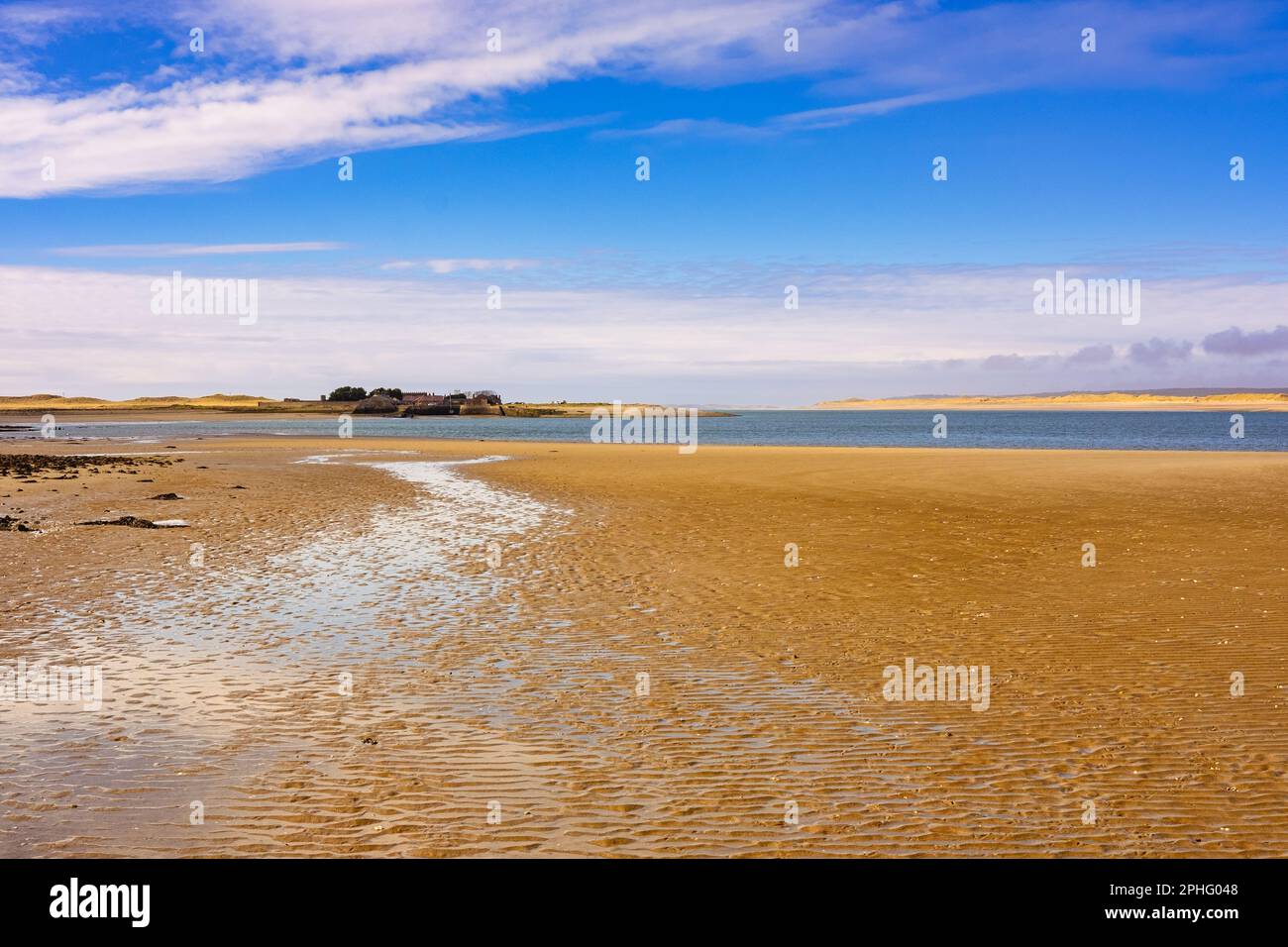 Blick über den Sand nach Fort Belan mit Newborough Beach auf Anglesey über Menai Strait. Dinas Dinlle, Caernarfon, Gwynedd, Nordwales, Vereinigtes Königreich, Großbritannien Stockfoto
