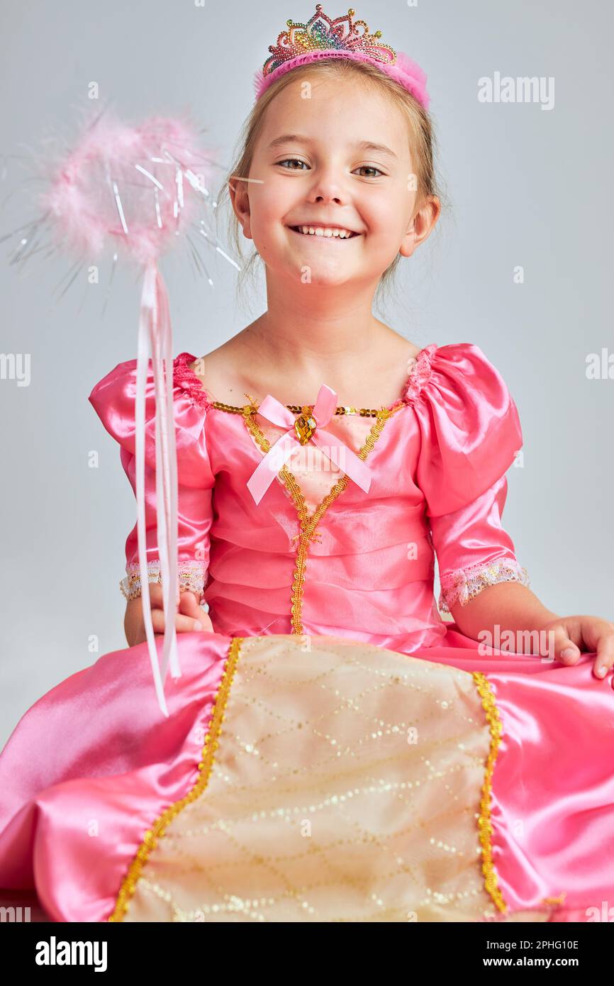 Kleines Mädchen genießen ihre Rolle der Prinzessin. Liebenswert niedlichen 5-6 Jahre altes Mädchen trägt rosa Prinzessin Kleid und Tiara auf einem Boden sitzen Stockfoto
