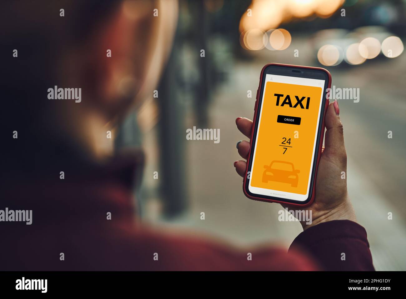 Frau, die Taxi online über die mobile App auf dem Smartphone bestellt. Taxibuchung über die Online-Anwendung. Ich organisiere eine Taxifahrt auf der Straße in der Innenstadt. Autovermietung Stockfoto