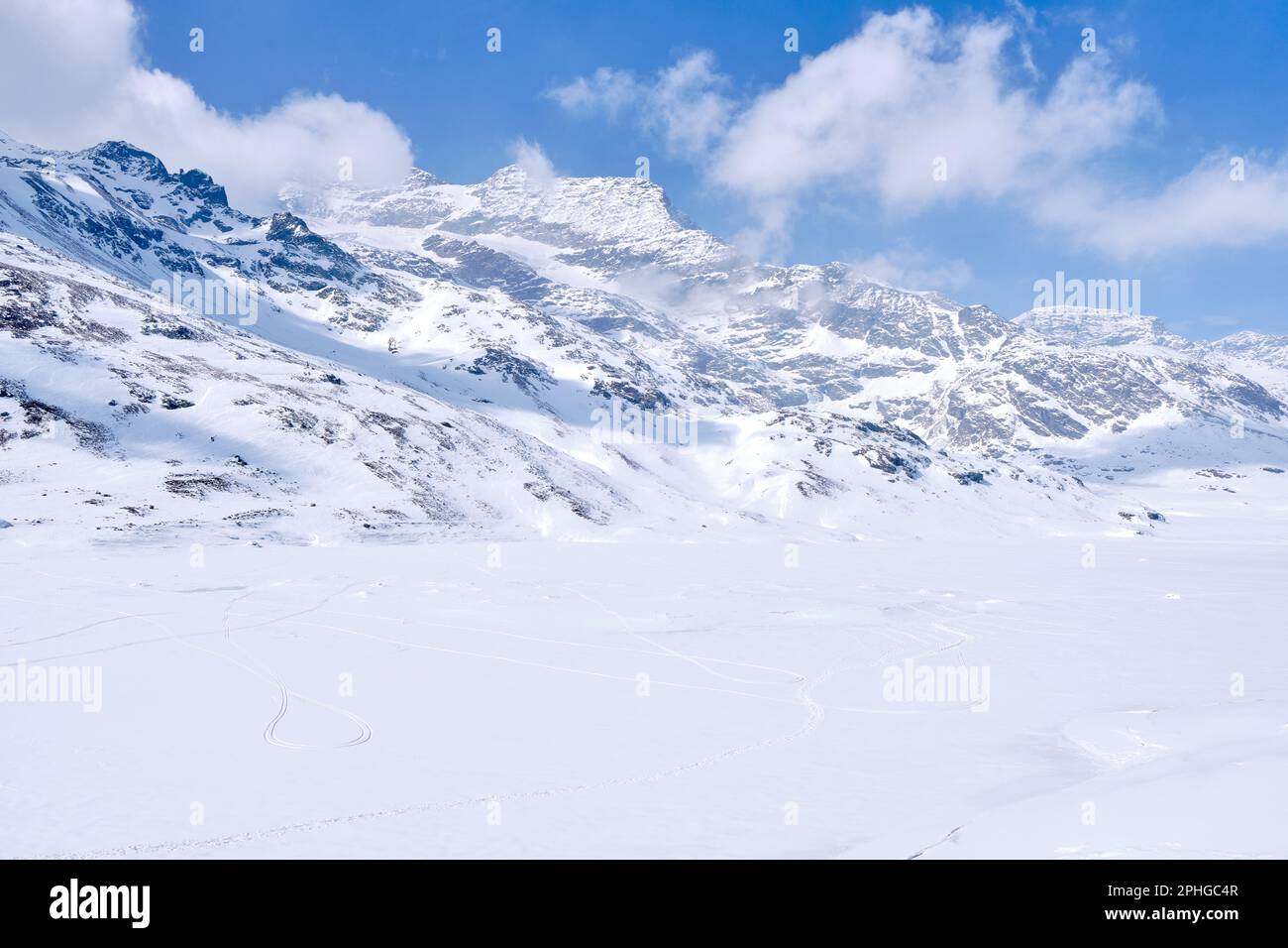 BERNINA Gebirgspass. Der berühmte rote Zug überquert den weißen See. Atemberaubende Landschaft des Schweizer Landes. Berühmtes Reiseziel und Touristen und Stockfoto