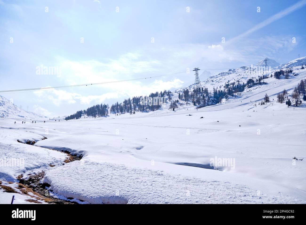 Der berühmte Schweizer Bergzug Bernina Express überquerte die italienischen und schweizer Alpen in blauem Himmel Stockfoto