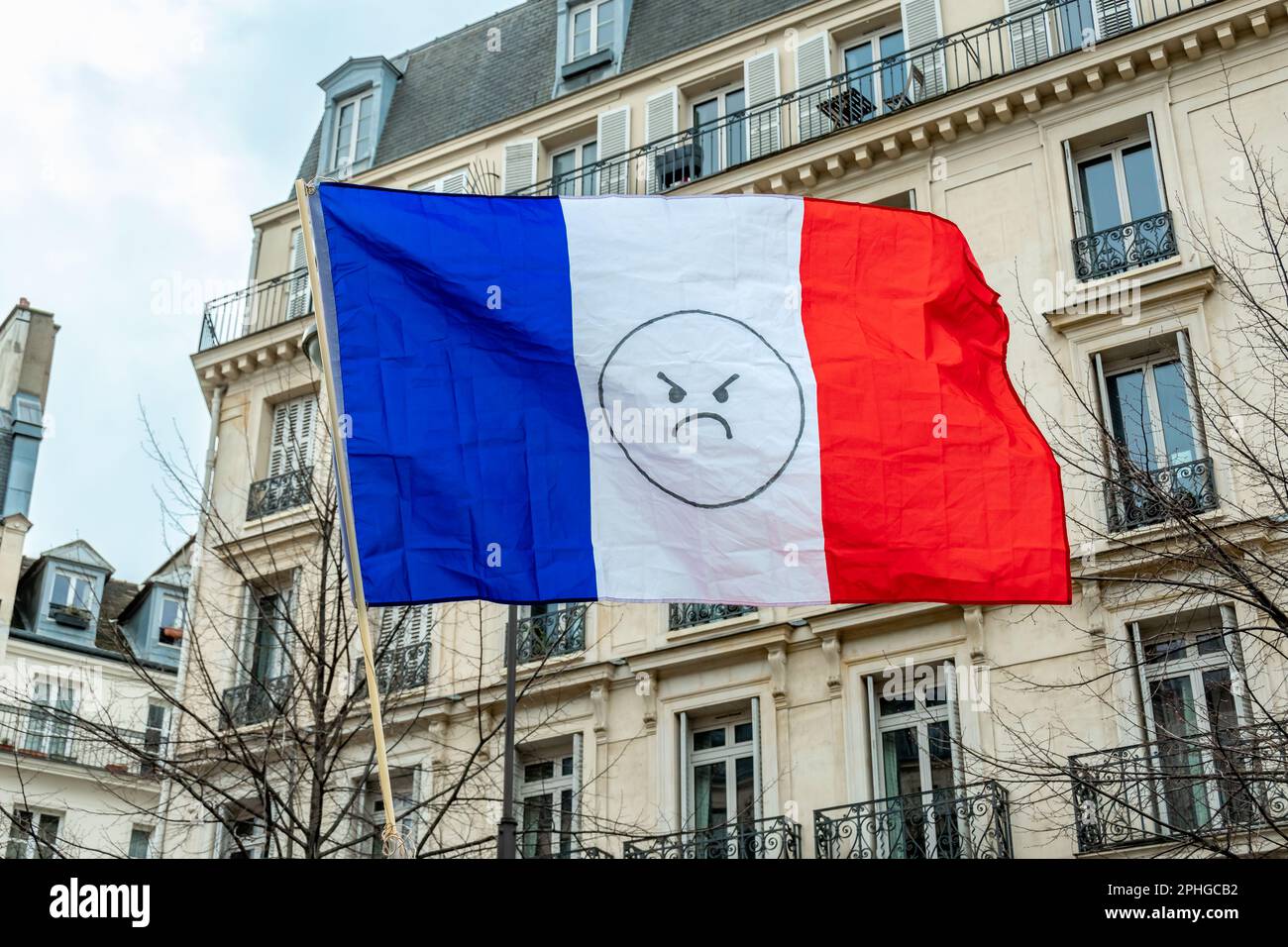 Französische Flagge mit einem Emoticon-Symbol der Wut. Nahaufnahme während eines Protestes gegen die Rentenreform in Frankreich Stockfoto