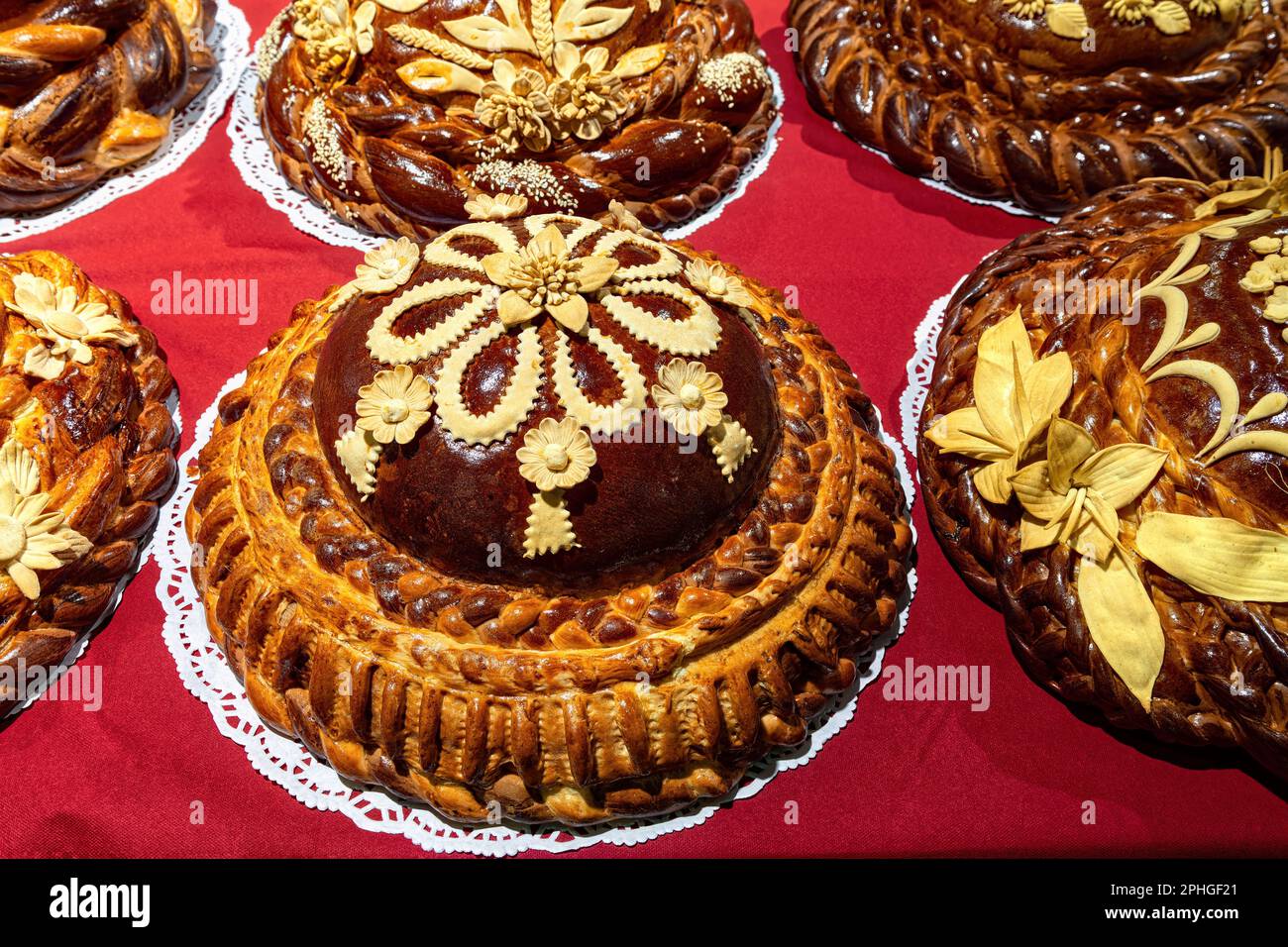 Traditionelles ukrainisches Hochzeitsbrot isoliert auf rotem Hintergrund. Rundes Laib-Hochzeitsbrot mit Blick von oben. Stockfoto