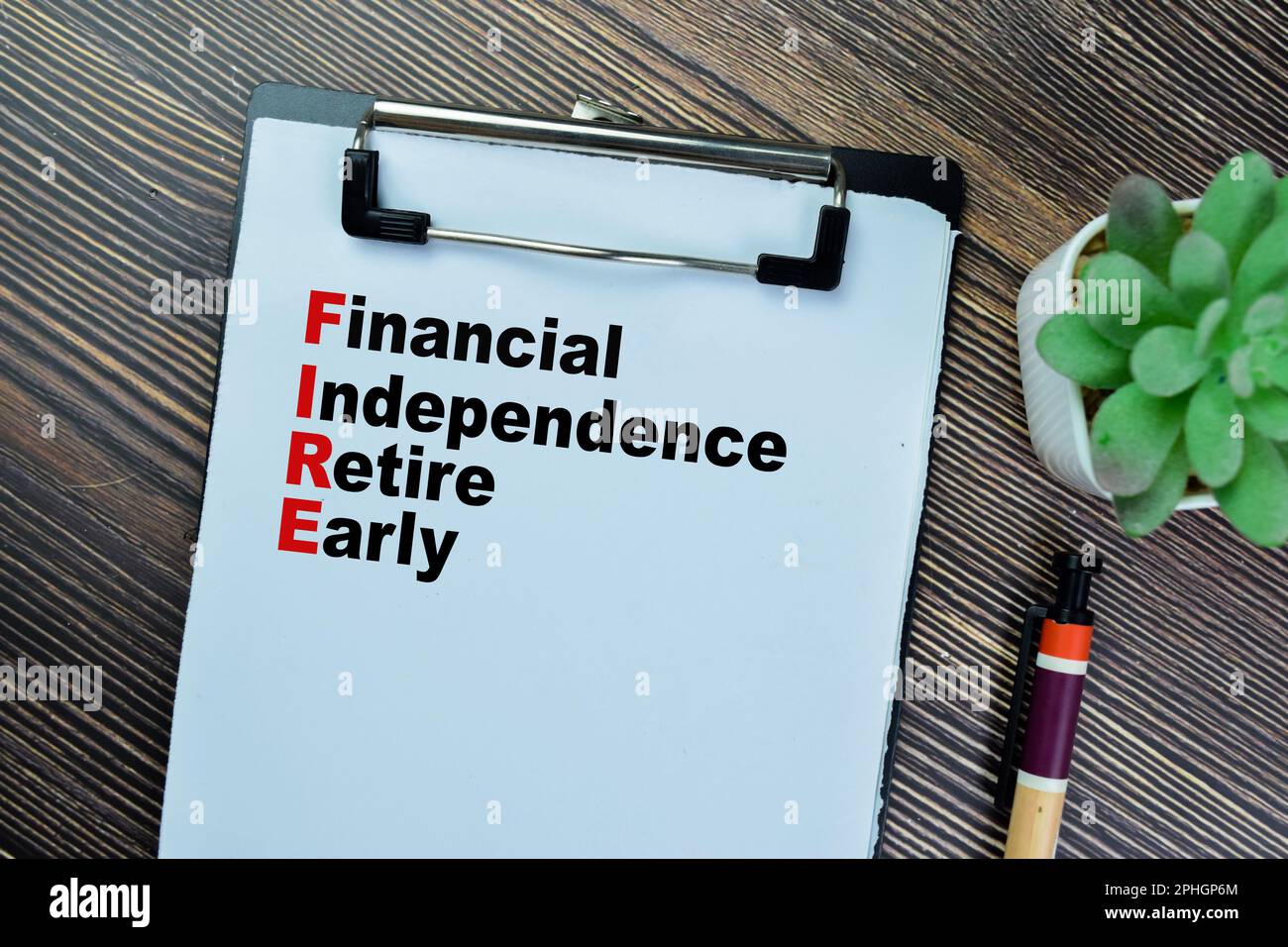 Konzept der finanziellen Unabhängigkeit pensionieren Sie frühzeitig über Papierkram auf einem Buch, isoliert auf einem Holztisch. Stockfoto Konzept der finanziellen Unabhängigkeit pensionieren Sie frühzeitig über Papierkram auf einem Buch, isoliert auf einem Holztisch. Stockfoto