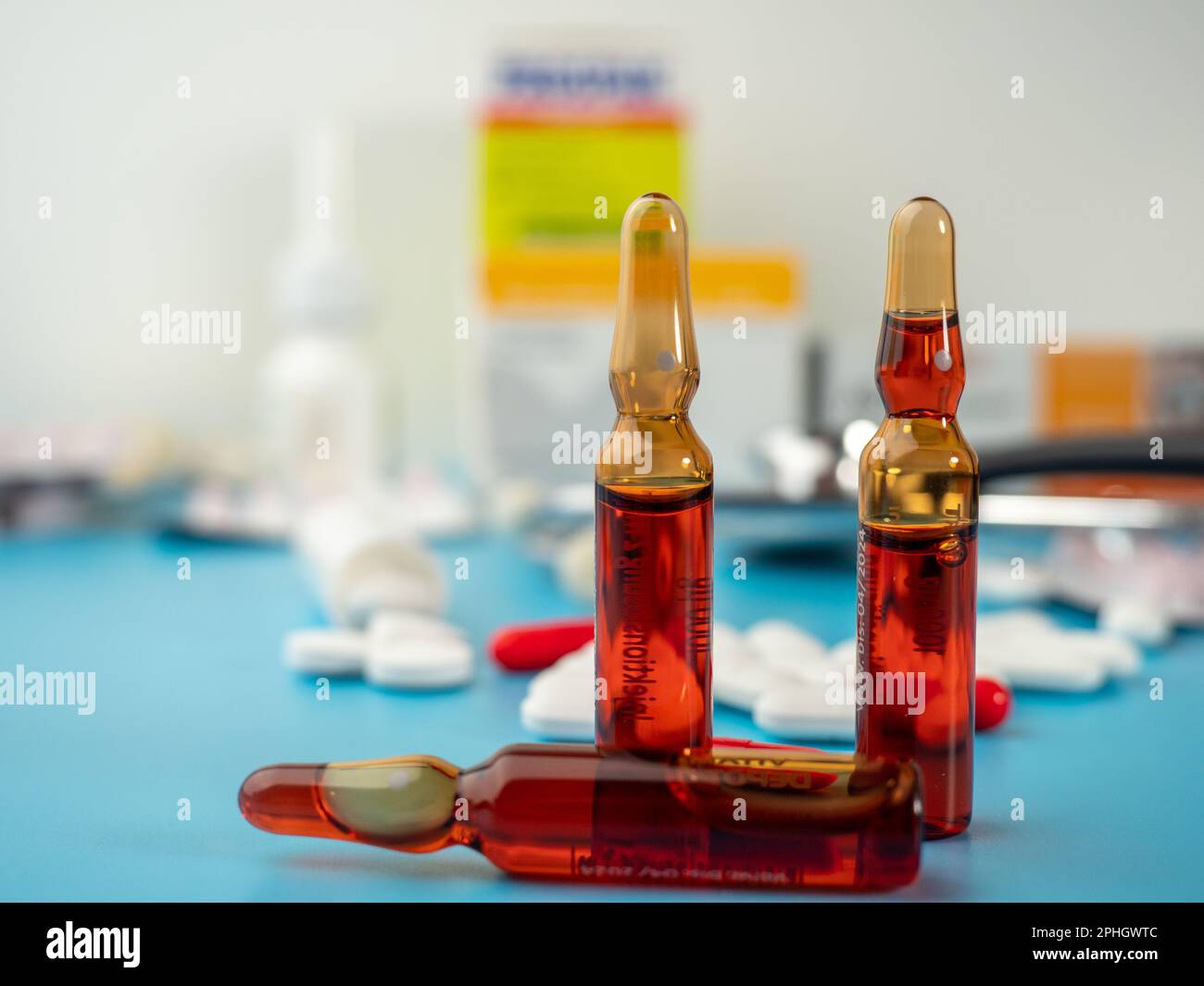 Arzneimittel auf blauem Hintergrund. Kapseln und Tabletten und Ampullen. Nahaufnahme. Stockfoto