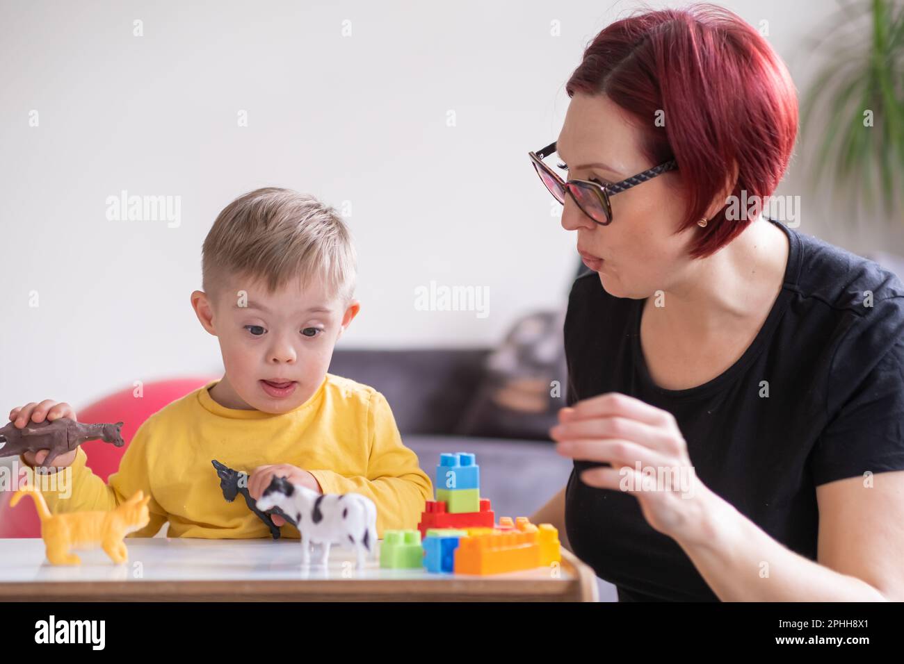 Förderplan Kinder Mit Down-syndrom Kleiner Junge, der mit Down-Syndrom lebt, mit Spielzeug, das