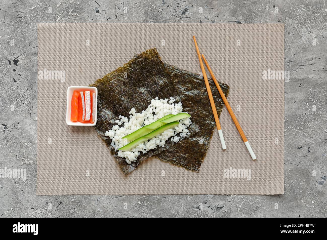 Nori und Zutaten für die Zubereitung von Sushi-Brötchen auf Grunge-Hintergrund Stockfoto