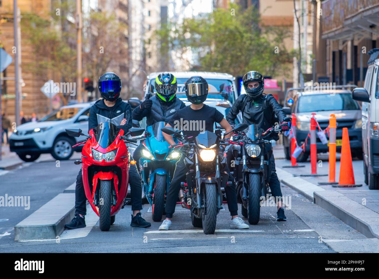 Vier Motorradfahrer, die vor der Kamera standen und Integralhelme trugen, hielten an einer Kreuzung in Pitt Street, Sydney, Australien Stockfoto